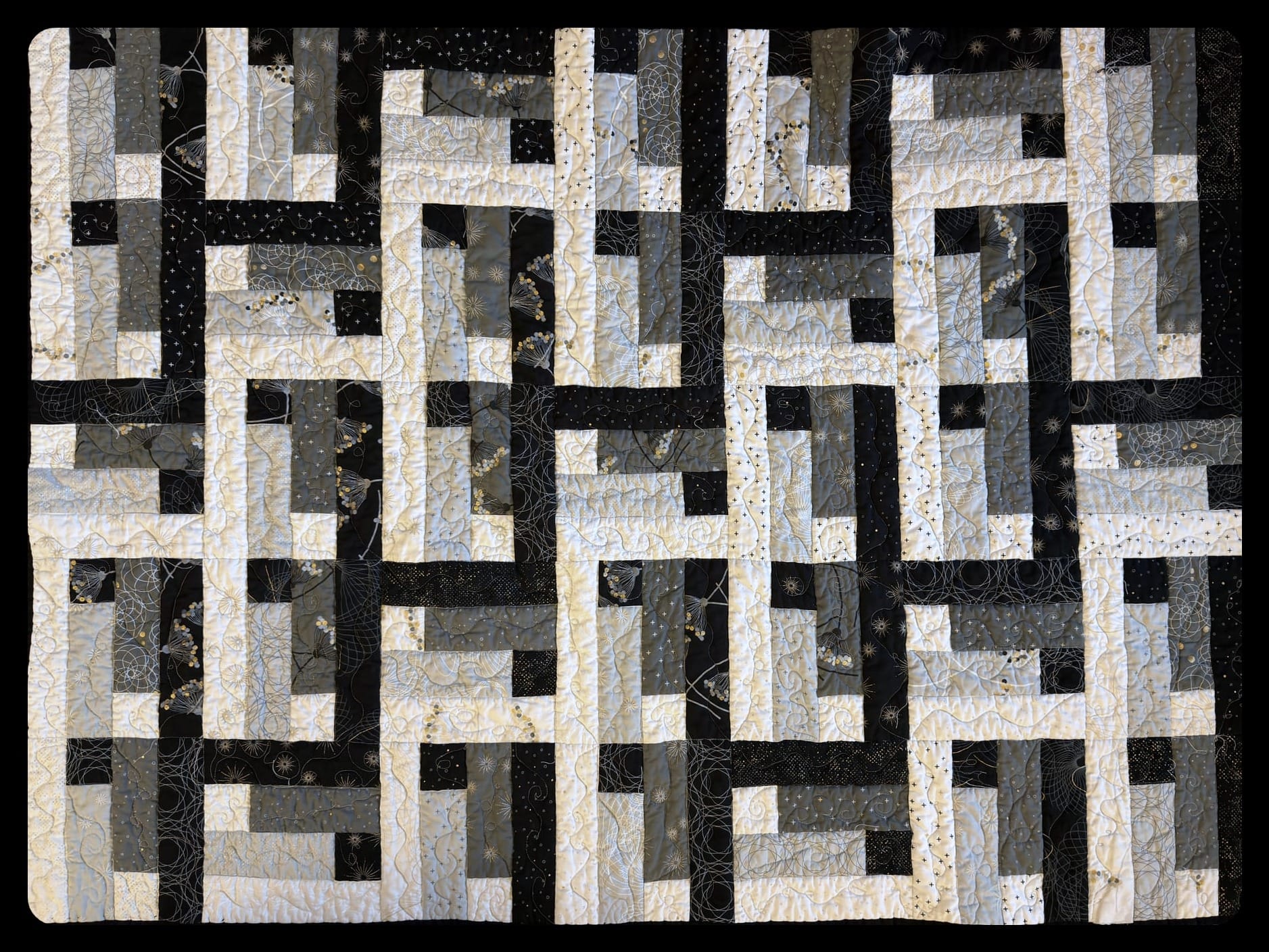 quilted with some texture, a blanket with black and white of the quilt lying on a bed, showing the pattern of woven stairs